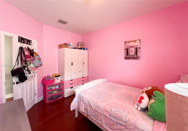 bedroom with wood finished floors and visible vents