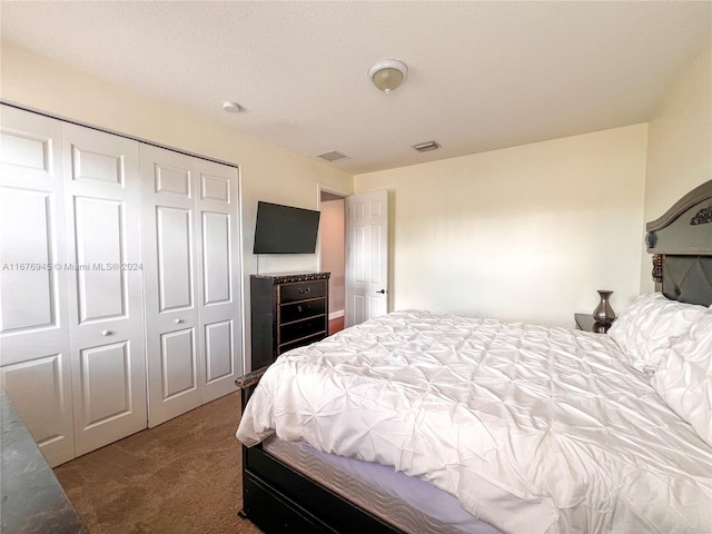 carpeted bedroom with a textured ceiling and a closet