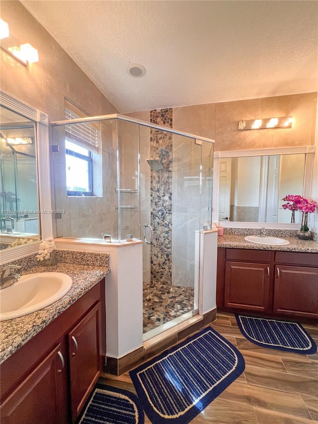 bathroom featuring vanity, a textured ceiling, walk in shower, and hardwood / wood-style flooring