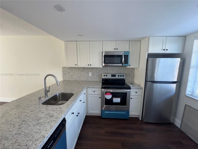 kitchen with decorative backsplash, stainless steel appliances, sink, white cabinetry, and dark hardwood / wood-style flooring