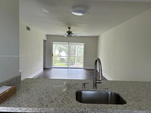 kitchen with ceiling fan, hardwood / wood-style flooring, light stone countertops, and sink