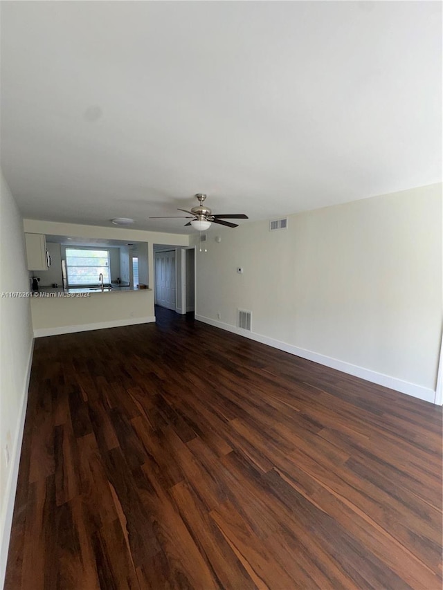 unfurnished living room featuring sink, ceiling fan, and dark hardwood / wood-style flooring