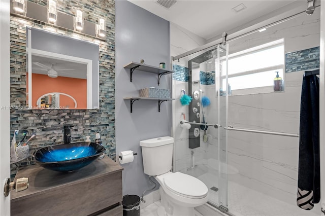 bathroom featuring a shower with door, vanity, decorative backsplash, and toilet