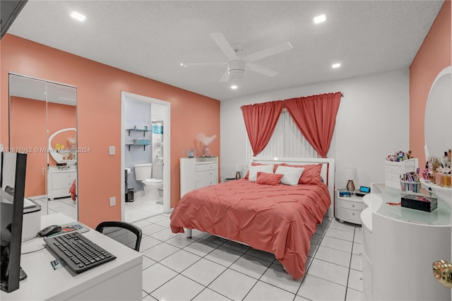 tiled bedroom featuring ceiling fan, a textured ceiling, and ensuite bathroom