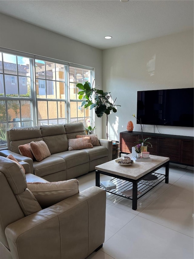 living room with a textured ceiling and light tile patterned flooring