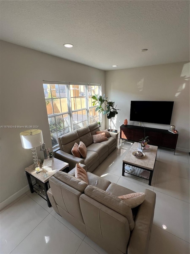 living room with a textured ceiling and light tile patterned floors