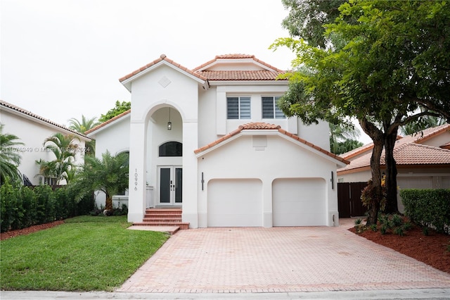 mediterranean / spanish-style house featuring a front lawn and a garage