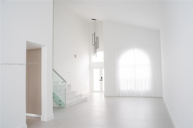 unfurnished room featuring high vaulted ceiling