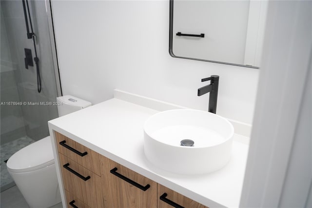 bathroom with vanity, a shower with shower door, and toilet