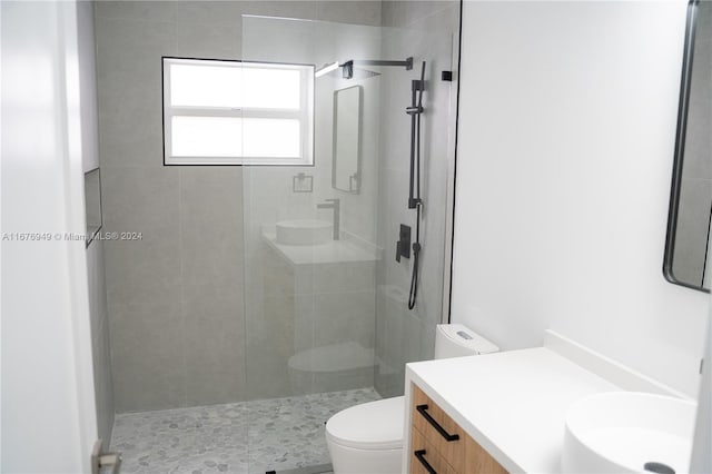 bathroom with toilet, an enclosed shower, and vanity