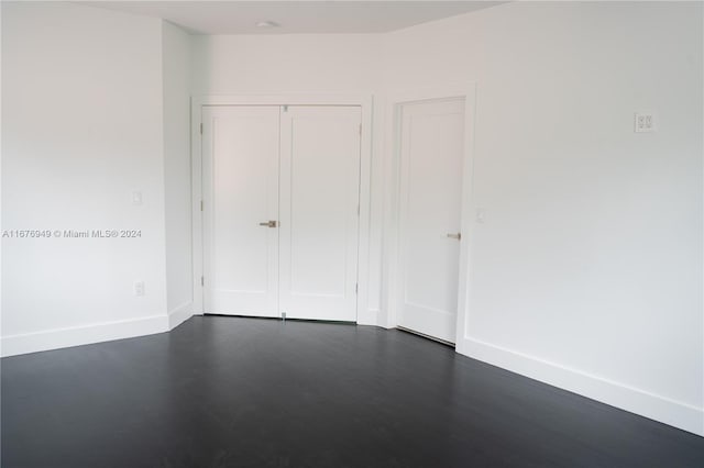 unfurnished bedroom with a closet and dark wood-type flooring