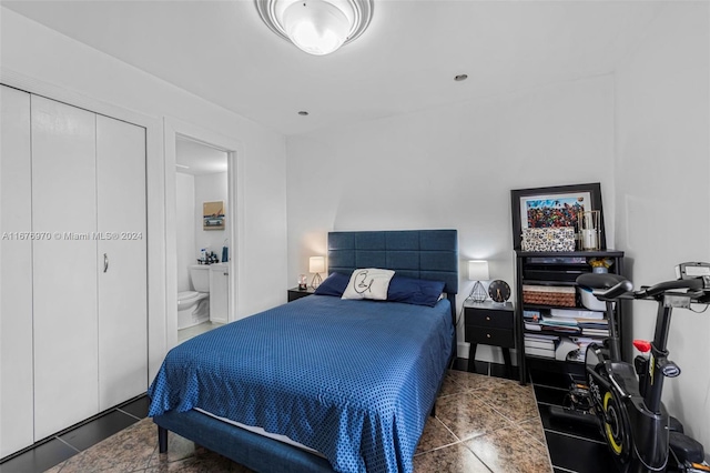 tiled bedroom featuring a closet and ensuite bath