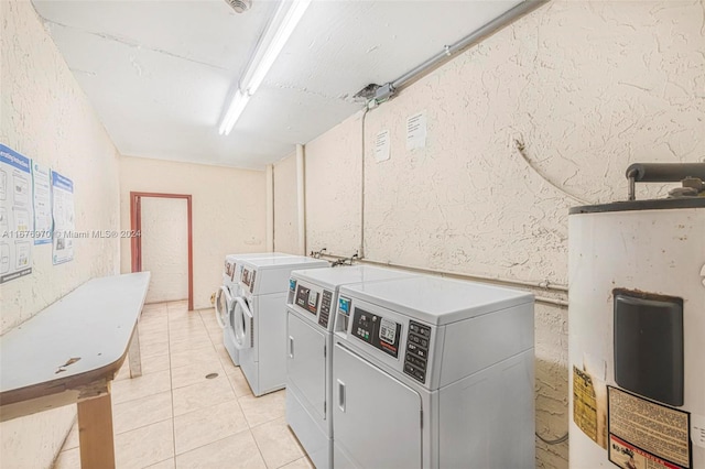 washroom featuring light tile patterned flooring, washer and clothes dryer, and water heater