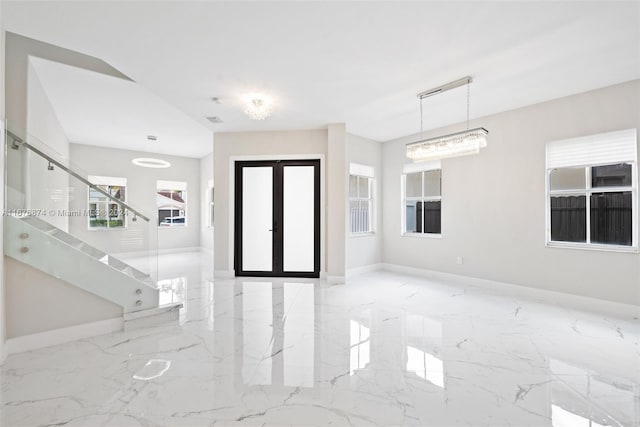 entryway featuring french doors, a chandelier, and plenty of natural light