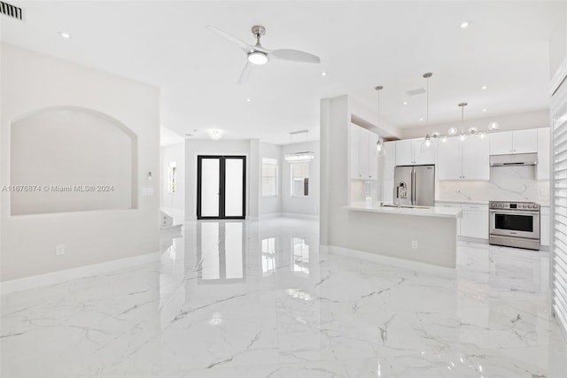 kitchen with french doors, stainless steel appliances, decorative light fixtures, white cabinets, and ceiling fan with notable chandelier