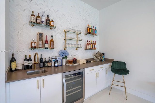 bar with wine cooler, sink, and white cabinets