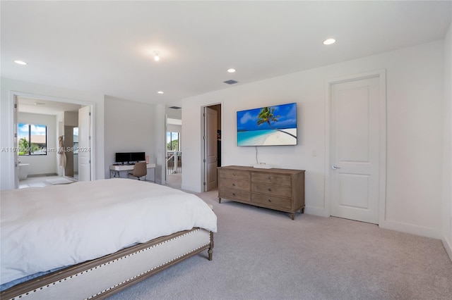 bedroom with light carpet and ensuite bath