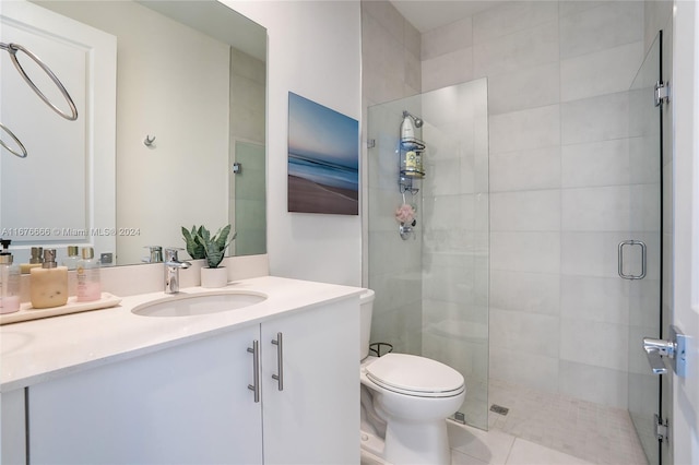 bathroom with vanity, toilet, tile patterned flooring, and a shower with door