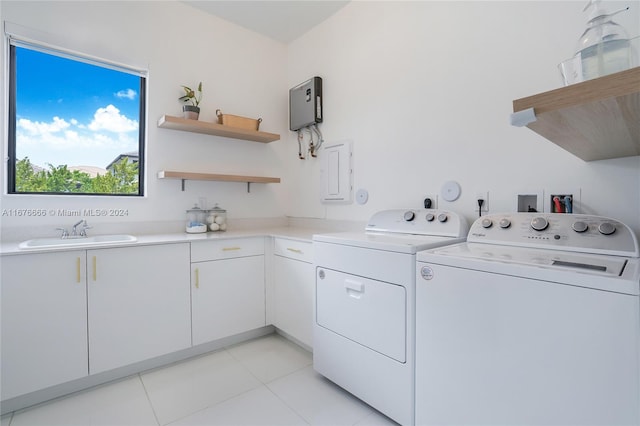 washroom featuring light tile patterned floors, cabinets, sink, and washer and clothes dryer