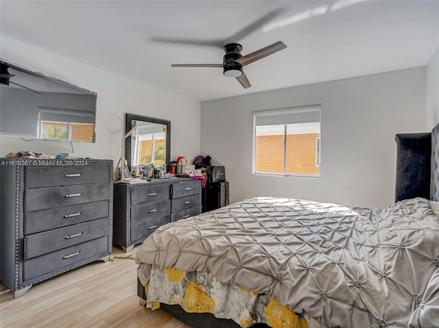 bedroom with ceiling fan, multiple windows, and light wood-type flooring