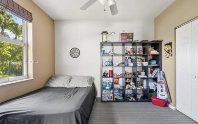 bedroom with ceiling fan, a closet, and multiple windows