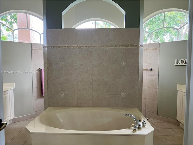 bathroom with a healthy amount of sunlight, a washtub, and vanity