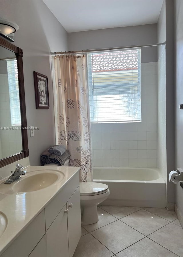 full bathroom featuring toilet, tile patterned floors, vanity, and shower / tub combo with curtain