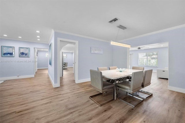 dining area featuring ceiling fan, light hardwood / wood-style floors, and ornamental molding