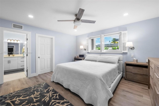 bedroom featuring ceiling fan, ensuite bathroom, and light wood-type flooring