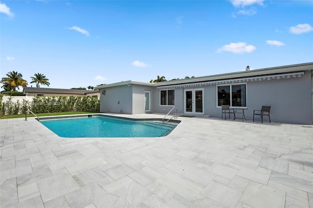 view of swimming pool with a patio and french doors