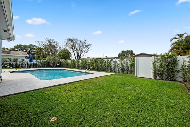 view of pool featuring a yard, a storage unit, and a patio area