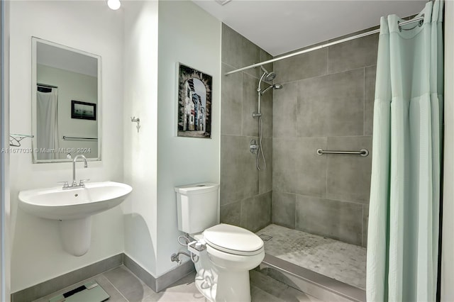 bathroom with toilet, curtained shower, and tile patterned flooring