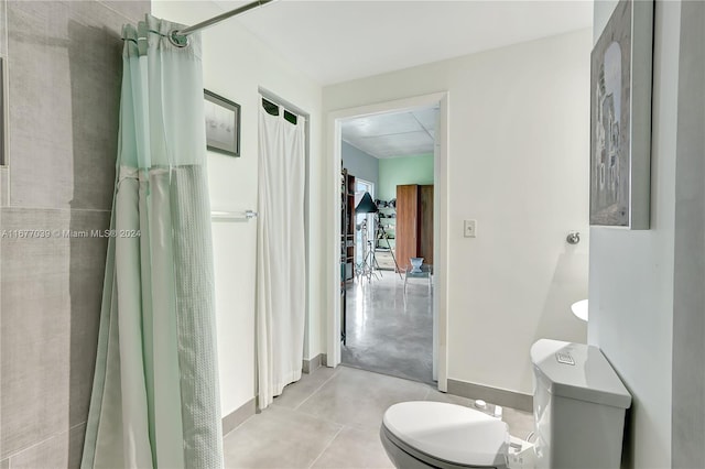 bathroom featuring concrete flooring, a shower with shower curtain, and toilet