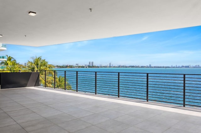 view of patio / terrace featuring a water view, a balcony, and a city view