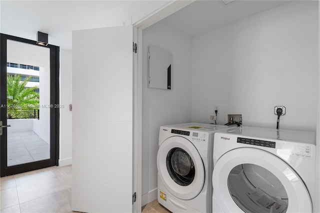 washroom featuring light tile patterned flooring, washer and dryer, and french doors