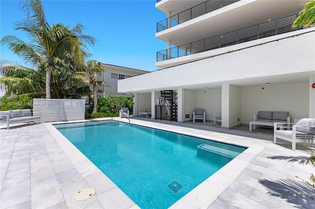 view of swimming pool with a patio area, an outdoor living space, and a fenced in pool