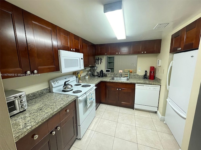 kitchen featuring light tile patterned flooring, sink, light stone counters, and white appliances