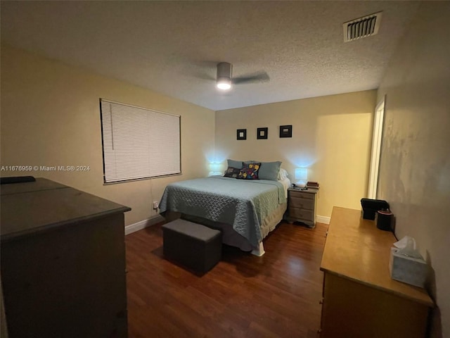 bedroom with dark wood-type flooring, a textured ceiling, and ceiling fan