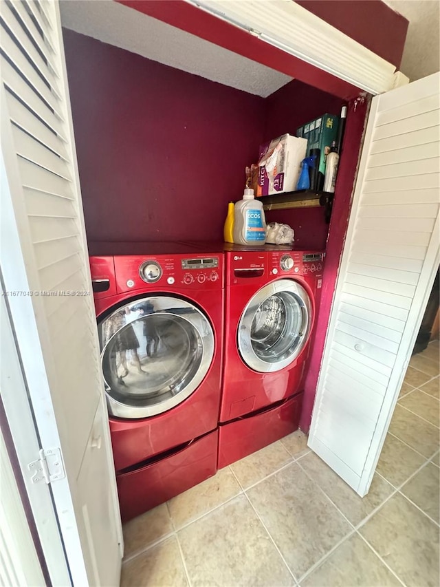 laundry area with light tile patterned flooring and washer and dryer