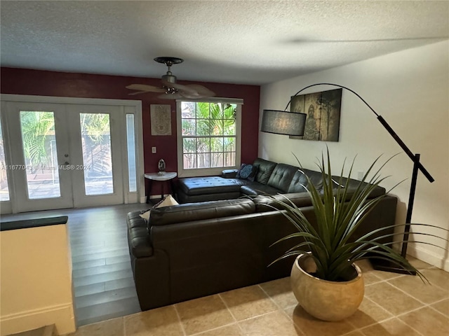 living room featuring french doors, ceiling fan, a textured ceiling, and light hardwood / wood-style flooring