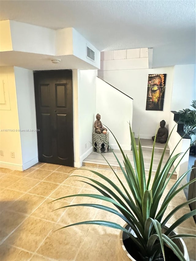 hall featuring a textured ceiling and tile patterned flooring