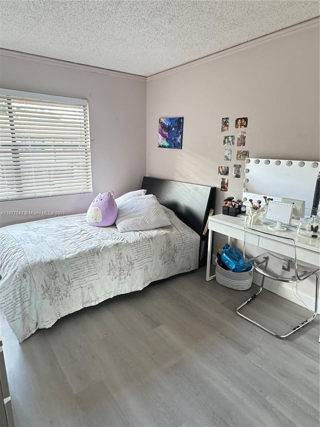 bedroom featuring hardwood / wood-style flooring and a textured ceiling