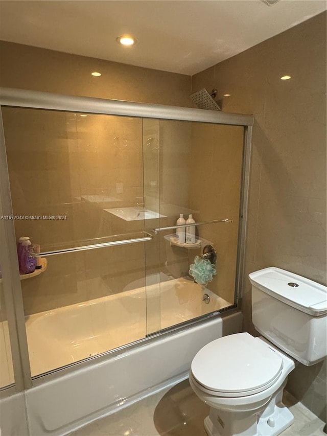 bathroom with toilet, enclosed tub / shower combo, and tile patterned flooring