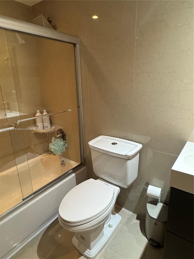 full bathroom featuring vanity, toilet, shower / bath combination with glass door, and tile patterned flooring