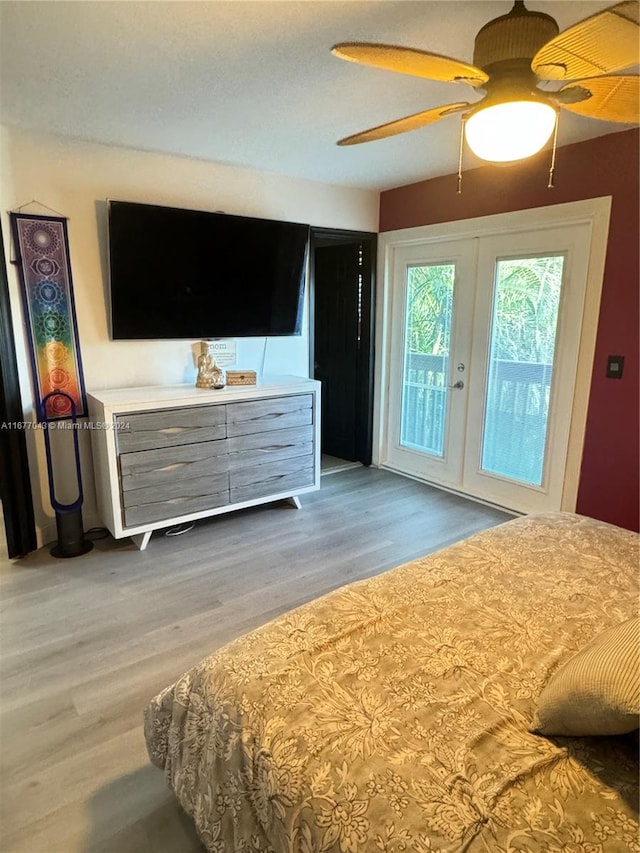 bedroom featuring french doors, access to exterior, wood-type flooring, and ceiling fan