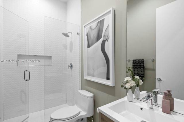 bathroom with vanity, a shower with shower door, and toilet