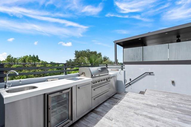 view of patio with sink, grilling area, area for grilling, and beverage cooler