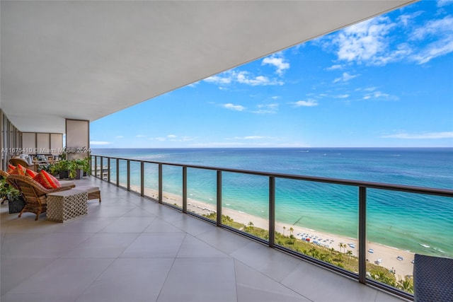 balcony featuring a water view and a beach view