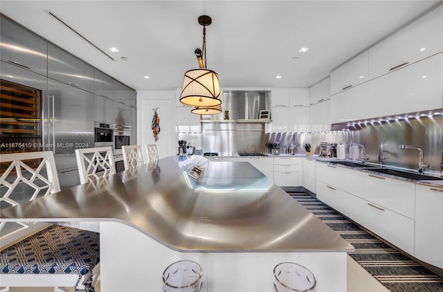 kitchen featuring sink, white cabinetry, pendant lighting, and tasteful backsplash