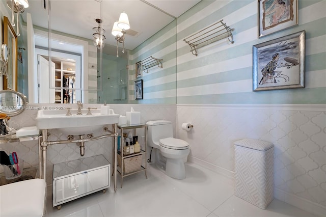 bathroom featuring toilet, sink, tile walls, and tile patterned flooring